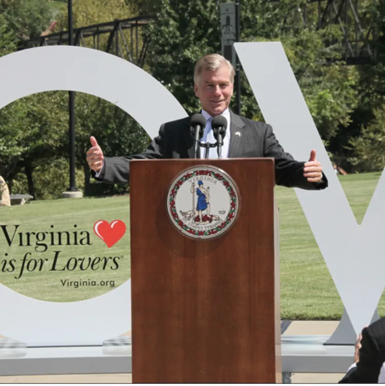 Governor Bob McDonnell standing at a podium, speaking. He is in front of a partially viewable LOVE sign, which says Virginia is for Lovers in the bottom left.