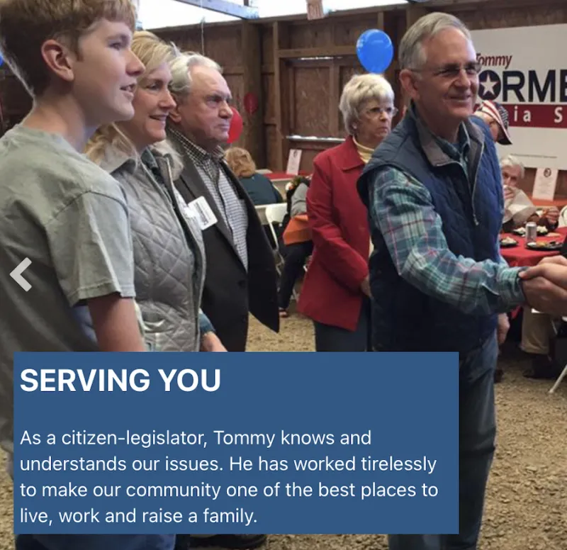 Tommy Norment, Virginia State Senator, dressed in a plaid shirt and a vest, reaches to shake hands with an unseen individual. He has four people behind hiA banner in the background has the partially viewable words "Tommy Norment Virginia Senate". There is a blue block at the bottom of the image that says "AS a citizen-legislator, Tommy knows and understands our issues. He has worked tirelessly to make our community one of the best places to live, work and raise a family."