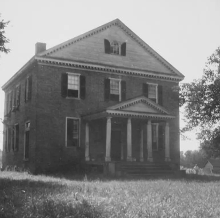 Photograph is of Aberdeen, a rectangular, two storied, flemish bond brick home with a metal gabled roof and a one-story front porch with a gabled roof and four Tuscan columns.