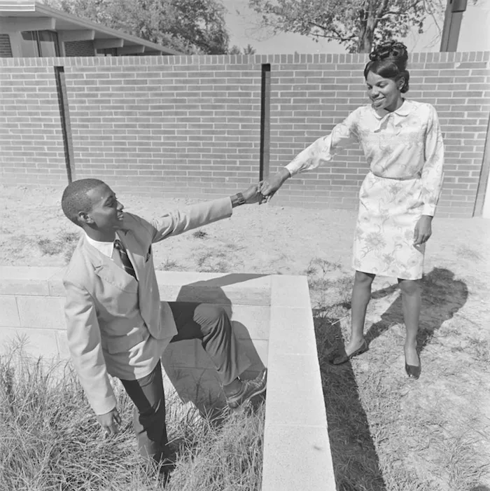Male and female student being playful outside school 